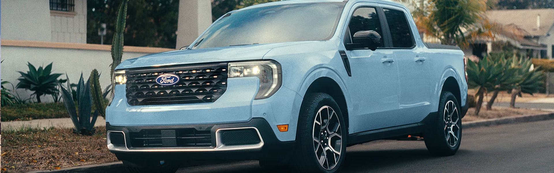 A light blue Ford truck parked on a street with palm trees