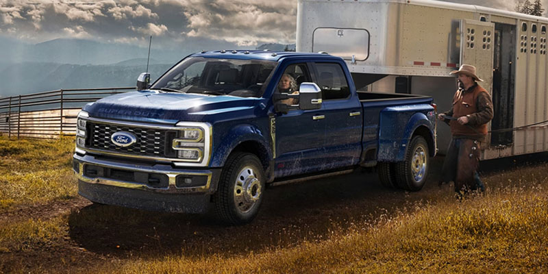 A Ford Super Duty truck towing a trailer in a field