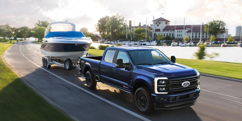 2026 Ford F-250 Super Duty towing a boat through a Benton, AR neighborhood with powerful hauling capability