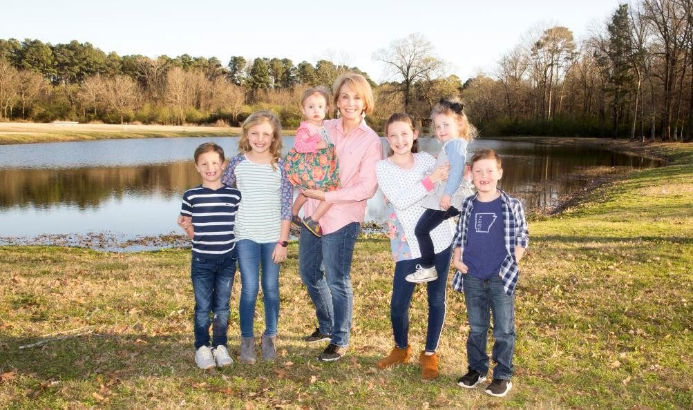 Family photo of the Everetts, standing in front of a lake